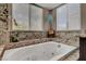 Bright bathroom featuring a soaking tub with granite surround and two large sunny windows at 2429 Sun Shores Dr, Las Vegas, NV 89128