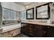 Luxurious bathroom with double sink vanity, soaking tub with granite surround, and modern lighting at 2429 Sun Shores Dr, Las Vegas, NV 89128