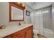 Bathroom featuring wood vanity, large mirror, and shower with neutral tile at 2429 Sun Shores Dr, Las Vegas, NV 89128