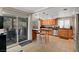 Bright kitchen with outdoor access, granite counters, wooden cabinets, and stainless appliances at 2429 Sun Shores Dr, Las Vegas, NV 89128