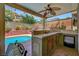 Outdoor kitchen features a tile countertop, sink, storage, and built-in grill near the pool at 2429 Sun Shores Dr, Las Vegas, NV 89128
