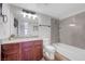 Updated bathroom features a granite countertop, wood cabinet, and shower over tub at 2451 N Rainbow Blvd # 2144, Las Vegas, NV 89108