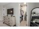 Bedroom featuring dresser with TV, mirror, open walk-in closet with clothes and storage above at 2451 Old Forge Ln # 105, Las Vegas, NV 89121