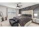 Bedroom with large bed, tufted headboard, bench, decorative wall, and two dressers at 2451 Old Forge Ln # 105, Las Vegas, NV 89121