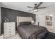 Bedroom featuring a tufted headboard, decorative wall, fan, and loft access at 2451 Old Forge Ln # 105, Las Vegas, NV 89121