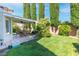 Private backyard with well-maintained lawn, patio area, barbecue grill, and lush landscaping at 2708 Norbeck St, Las Vegas, NV 89117
