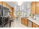 Well-lit kitchen featuring wooden cabinets, white tile flooring, and view to dining and living areas at 2708 Norbeck St, Las Vegas, NV 89117
