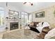 Cozy living room featuring a fireplace, neutral carpet, and large windows with shutter style window covers at 2708 Norbeck St, Las Vegas, NV 89117