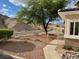 Inviting desert home has a white fence and mature tree providing ample shade at 3349 Partridge Run St, Laughlin, NV 89029