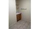 Neutral-colored laundry room with tile flooring, a basin and wooden cabinets at 3349 Partridge Run St, Laughlin, NV 89029