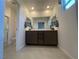 Bright bathroom featuring double vanity sinks, a large mirror, and a walk-in shower at 3534 Alpheus River Ave, Las Vegas, NV 89106