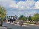 Community entrance with desert landscaping, palm trees, and views of neighborhood homes at 3534 Alpheus River Ave, Las Vegas, NV 89106