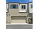 Contemporary townhome with a two-car garage, neutral stucco exterior, and modern architectural details at 3534 Alpheus River Ave, Las Vegas, NV 89106