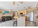 Open-concept kitchen and dining area with wood cabinets, breakfast bar, and modern appliances at 3661 Margarita Way, Las Vegas, NV 89103