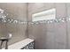 Detail of the tiled shower with a built-in bench and decorative accents at 3661 Margarita Way, Las Vegas, NV 89103