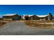 Desert property features a neutral-toned single-story home with a detached garage and gravel driveway at 3750 S Rainbow Ave, Pahrump, NV 89048