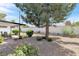 Spacious backyard featuring a covered patio, mature landscaping, and decorative gravel at 3805 San Angelo Ave, Las Vegas, NV 89102
