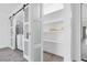Bright laundry and storage area with sliding barn doors and gray flooring at 3805 San Angelo Ave, Las Vegas, NV 89102