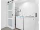 Close-up view of laundry area showing washer and dryer behind sliding barn doors at 3805 San Angelo Ave, Las Vegas, NV 89102