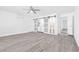 Bright living room with ceiling fan, air conditioner, gray floors, and sliding barn door to laundry area at 3805 San Angelo Ave, Las Vegas, NV 89102
