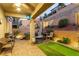 Well-maintained backyard with a patio, seating area, putting green, and lush landscaping at 39 Castleton Tower Ct, Henderson, NV 89011
