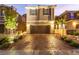 Charming two-story home featuring a two-car garage and a brick paved driveway surrounded by lush landscaping at 39 Castleton Tower Ct, Henderson, NV 89011