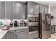 Modern kitchen featuring stainless appliances, granite countertops and grey cabinetry at 39 Castleton Tower Ct, Henderson, NV 89011