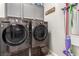 The laundry room showcases modern gray cabinets and gray washer and dryer set at 39 Castleton Tower Ct, Henderson, NV 89011