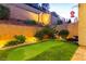 Backyard with a putting green and lush landscaping, enhanced by brick retaining walls at 39 Castleton Tower Ct, Henderson, NV 89011