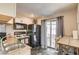 Well-lit kitchen features dark appliances, a double sink, breakfast bar, and sliding glass doors to the backyard at 3912 Palos Verdes St, Las Vegas, NV 89119