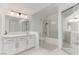 A bright, full bathroom with double mirrors, vanity, tub with shower, toilet, and tile flooring at 3930 University Center Dr # 208, Las Vegas, NV 89119