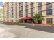 View of building exterior with palm trees, red awning over the entry, and drive-up access at 3930 University Center Dr # 208, Las Vegas, NV 89119