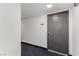 Well-maintained hallway with dark carpet and painted gray unit door at 3930 University Center Dr # 208, Las Vegas, NV 89119