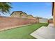 Fully fenced backyard features tidy artificial turf and convenient storage shed at 4078 Blue Manor Ln, North Las Vegas, NV 89032