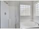 Bright bathroom featuring a separate shower and a soaking tub with glass block windows at 4078 Blue Manor Ln, North Las Vegas, NV 89032