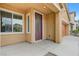 Covered front porch featuring beige siding and an oval glass front door at 4078 Blue Manor Ln, North Las Vegas, NV 89032