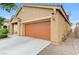 Attached two-car garage with traditional carriage doors, beige siding, and concrete driveway at 4078 Blue Manor Ln, North Las Vegas, NV 89032