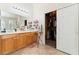 Bathroom featuring double vanity, well-lit mirror, and direct access to closet at 4329 Skimmers Ct, North Las Vegas, NV 89084