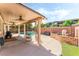 Covered patio featuring a ceiling fan, BBQ, and serene views of the backyard and pool at 4329 Skimmers Ct, North Las Vegas, NV 89084