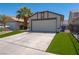 Charming home featuring a spacious garage, driveway, and a low-maintenance artificial grass lawn at 4481 Faberge Ave, Las Vegas, NV 89115