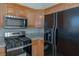 Open kitchen with stainless steel appliances, granite countertops, maple wood cabinets, and tile flooring at 4481 Faberge Ave, Las Vegas, NV 89115