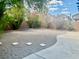 The property has a private backyard with lush greenery and stone accents at 4951 Ivylyn Ct, Las Vegas, NV 89122