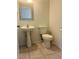 Cozy bathroom featuring pedestal sink, decorative mirror and toilet on neutral tile floor at 4951 Ivylyn Ct, Las Vegas, NV 89122