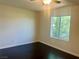 A bright bedroom featuring dark hardwood floors, a ceiling fan and a bright window at 4951 Ivylyn Ct, Las Vegas, NV 89122