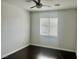 Modest bedroom with dark wood floors, ceiling fan, and window with blinds at 4951 Ivylyn Ct, Las Vegas, NV 89122