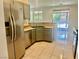 Bright kitchen with stainless appliances, tile flooring, bar seating, and sliding door access to the backyard at 4951 Ivylyn Ct, Las Vegas, NV 89122