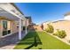 A private backyard featuring artificial grass, a brick paver patio, and well-maintained landscaping at 528 Sunny Pointe St, Henderson, NV 89011