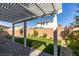Landscaped backyard featuring a pergola, artificial grass, and a brick paver patio for outdoor enjoyment at 528 Sunny Pointe St, Henderson, NV 89011