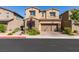 A two-story home featuring stone accents, a two-car garage, and professionally landscaped front yard at 528 Sunny Pointe St, Henderson, NV 89011