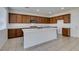 Spacious kitchen features an island, tile flooring, quartz countertops, stainless steel appliances, and wood cabinets at 528 Sunny Pointe St, Henderson, NV 89011